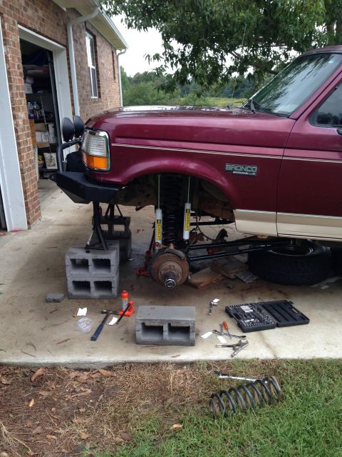 1996 Ford Bronco - A 1996 Ford Bronco is shown with its front suspension disassembled, indicating a lift kit installation is in progress.