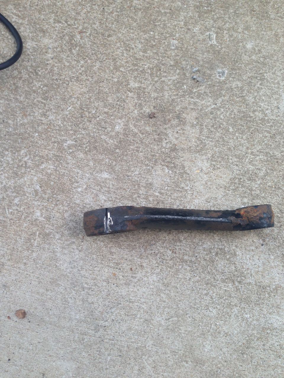 rusted metal bar with white marks on concrete