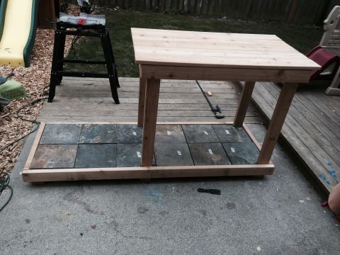 2008 Ford F-250 - Workbench with slate tiles on a wooden deck, next to a slide and a saw.