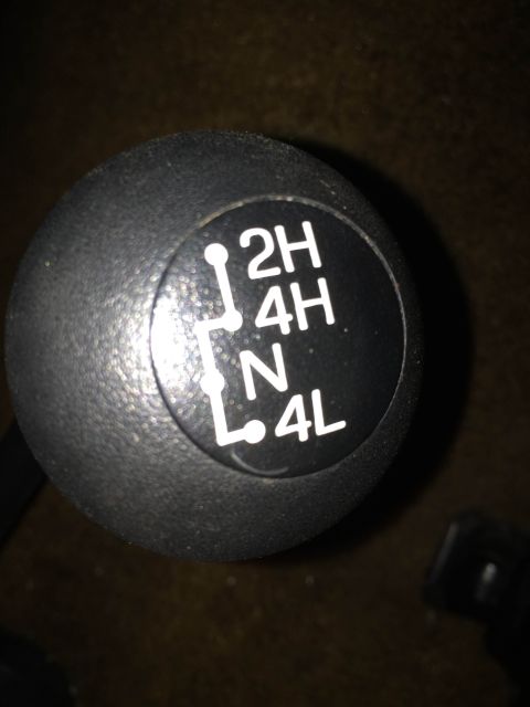 1990 Ford Bronco - Close-up of a transfer case shifter knob showing the different gear positions.