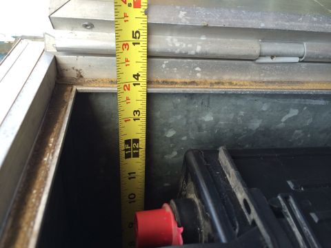 1986 Yugo GV - Measuring the depth of a battery box, which appears to be around 12 inches deep.