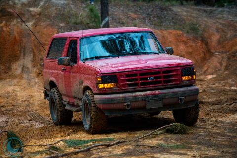 1995 Ford Bronco - This red 1995 Ford Bronco navigates a muddy, off-road course.