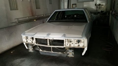 1991 Ford LTD Crown Victoria - Front view of a white Ford Crown Victoria undergoing repairs in a workshop.