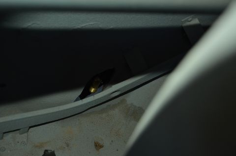 1979 Ford Bronco - Interior view of a metal bracket with a brass fitting, likely a component within a vehicle.