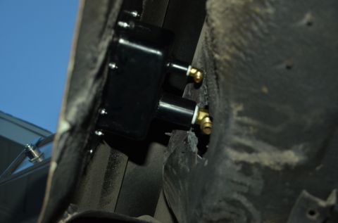1979 Ford Bronco - Underside view of a vehicle's undercarriage, showing a black component with brass fittings.