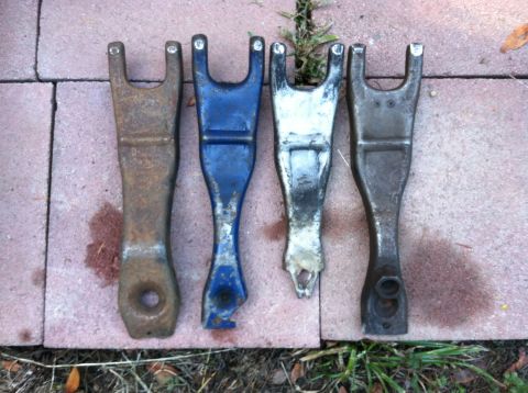 1968 Ford Torino - A collection of clutch forks, possibly for comparison or replacement, are displayed on a brick surface.