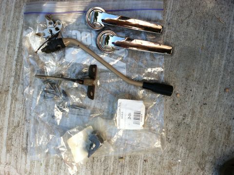 1968 Ford Torino - Car door handles and linkage parts are laid out on a concrete surface.