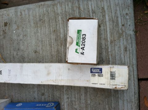 1968 Ford Torino - Two boxes of automotive parts, one labeled Clevite 229-1633 and the other Motor Warehouse K-A2083, are shown on a concrete surface.