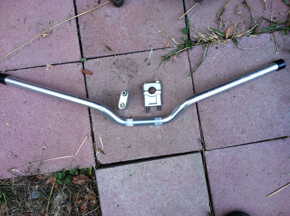 Silver motorcycle handlebars and triple clamp on pavers