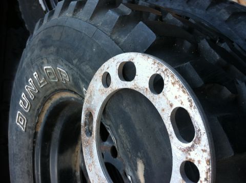 1968 Ford Torino - Close-up of a Dunlop tire and a metal wheel spacer, both automotive parts.