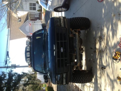 1996 Ford Bronco - This black Ford Bronco has a custom light bar and is missing its front bumper.
