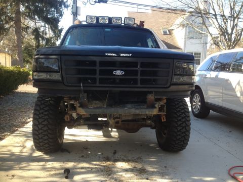 1996 Ford Bronco - Front view of a black 1996 Ford Bronco, modified with an aftermarket bumper and auxiliary lights on the roof.