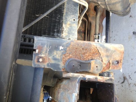 1996 Ford Bronco - Close-up of a heavily rusted metal bracket, likely part of a vehicle's front end structure.