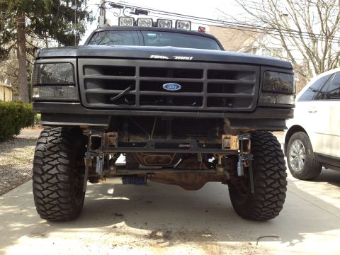1996 Ford Bronco - This black Ford Bronco features a custom front bumper and oversized tires, suggesting a model year earlier than 1996.
