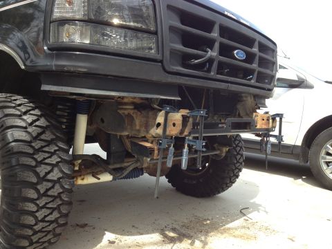 1996 Ford Bronco - Front view of a black 1996 Ford Bronco, showing the grille and modified bumper area with large off-road tires.