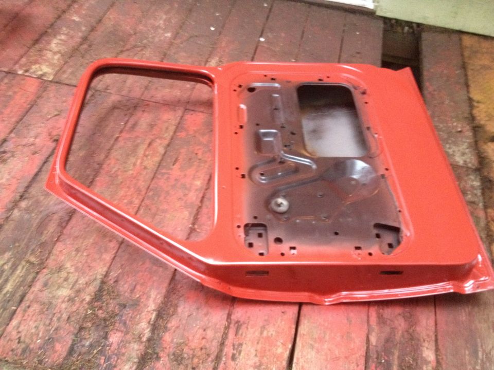 Red truck door, interior side visible, on wooden surface