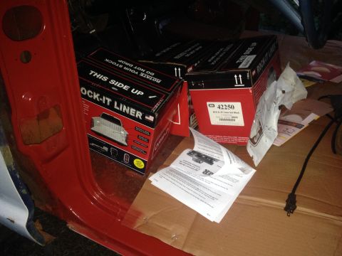 1971 Ford F-250 - Boxes of truck bed liner and instructions are laid out on cardboard inside a red vehicle door.
