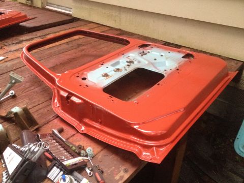 1971 Ford F-250 - A vehicle door is shown on a wooden surface, surrounded by various tools and hardware.
