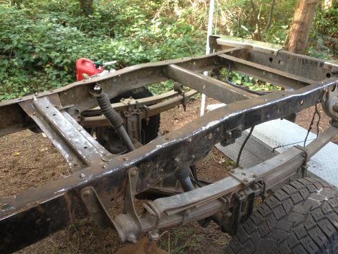 1971 Ford F-250 - Frame and suspension components of a truck, with a red jerry can in the background.