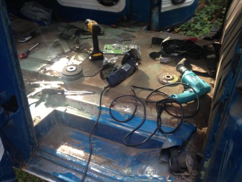 1971 Ford F-250 - Tools are laid out on the stripped floor of a truck cab, ready for restoration work.