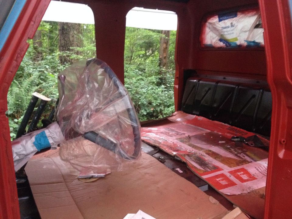 1971 Ford F-250 interior with a steering wheel covered in plastic and cardboard on the floor