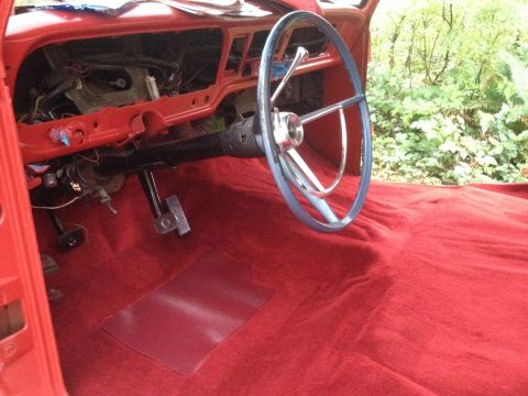 1971 Ford F-250 - The interior of a 1971 Ford F-250 shows a red carpet and a blue steering wheel, with the dashboard partially disassembled.