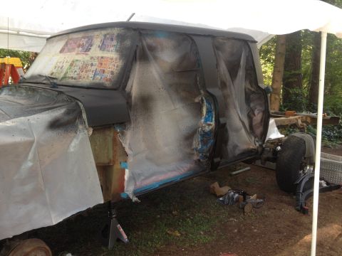 1971 Ford F-250 - The cab of a 1971 Ford F-250 is covered in plastic sheeting, likely for painting or bodywork.