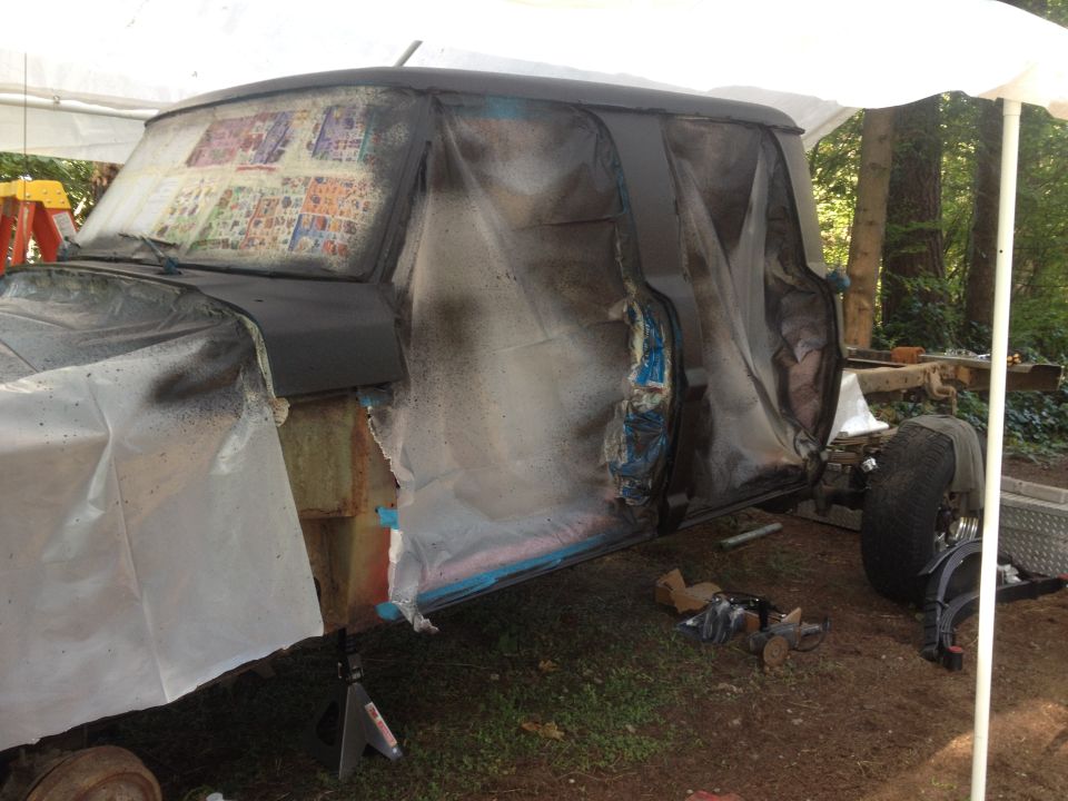 1971 Ford F-250 cab covered in plastic sheeting during paint prep
