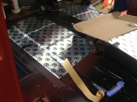 1971 Ford F-250 - Sound deadening material is being applied to the floor of a vehicle's interior.