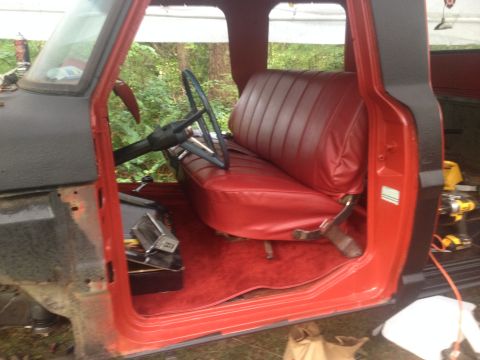 1971 Ford F-250 - Interior of a red truck cab with a bench seat and steering wheel, possibly a 1970s Ford F-Series.