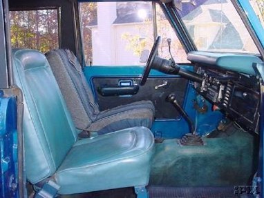1996 Ford Bronco - The interior of a blue SUV is shown, teal seats and dashboard details.