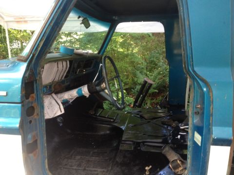 1971 Ford F-250 - The interior of a blue 1971 Ford F-250 truck is shown, with the dashboard and steering wheel visible.