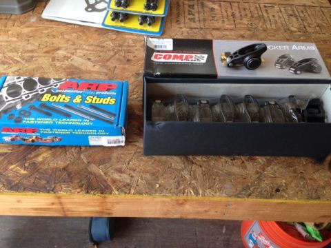 1996 Ford Bronco - Engine parts including ARP bolts and COMP Cams rocker arms are laid out on a wooden surface.
