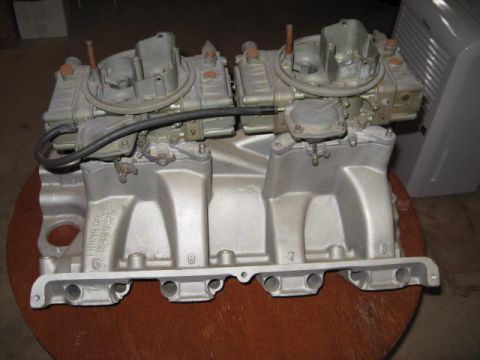 1963 Ford Galaxie - Aluminum dual carburetor intake manifold with two carburetors, part number visible on the side.