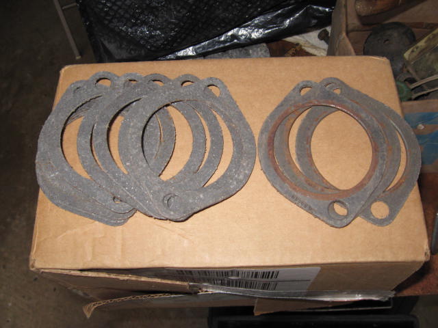 Stack of exhaust manifold gaskets on a cardboard box