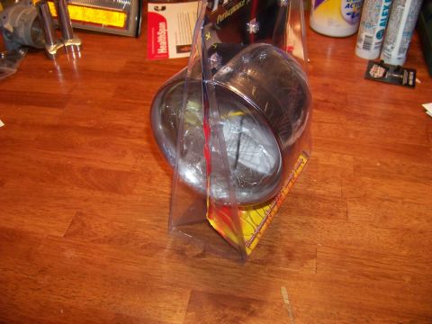 1995 Mercury Grand Marquis - A headlight is shown in its retail packaging on a wood-grain surface.