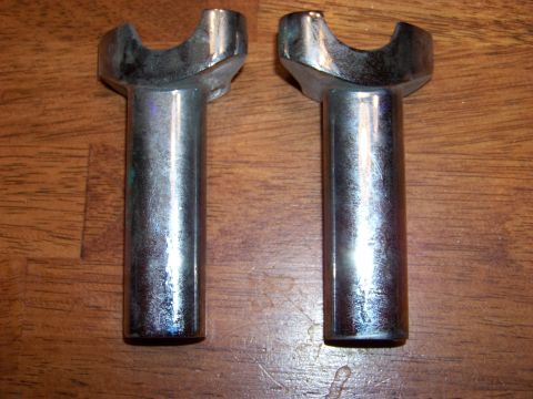 1995 Mercury Grand Marquis - Two chrome handlebars risers are shown against a wooden background. The registry claims they are from a 1995 Mercury Grand Marquis.