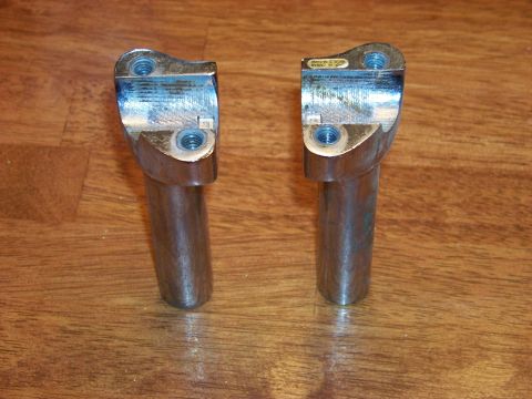 1995 Mercury Grand Marquis - Two chrome motorcycle handlebar risers are shown on a wooden surface.
