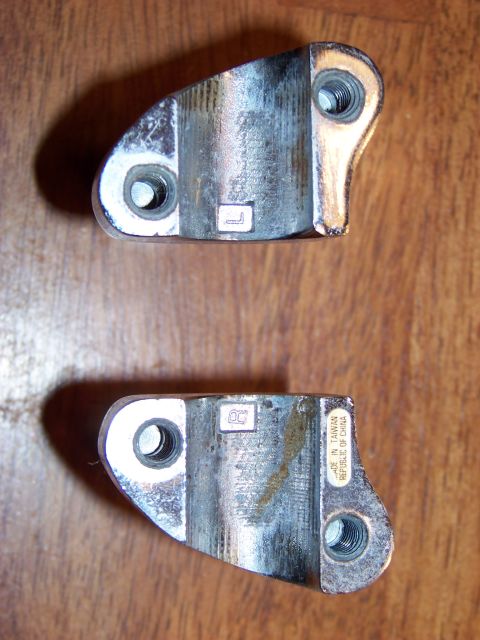 1995 Mercury Grand Marquis - Close-up view of two metal automotive parts, one bearing a country of origin sticker.