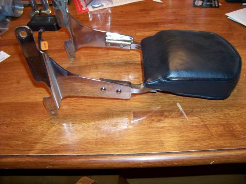 1995 Mercury Grand Marquis - Motorcycle backrest and chrome mounting hardware are displayed on a wooden surface.