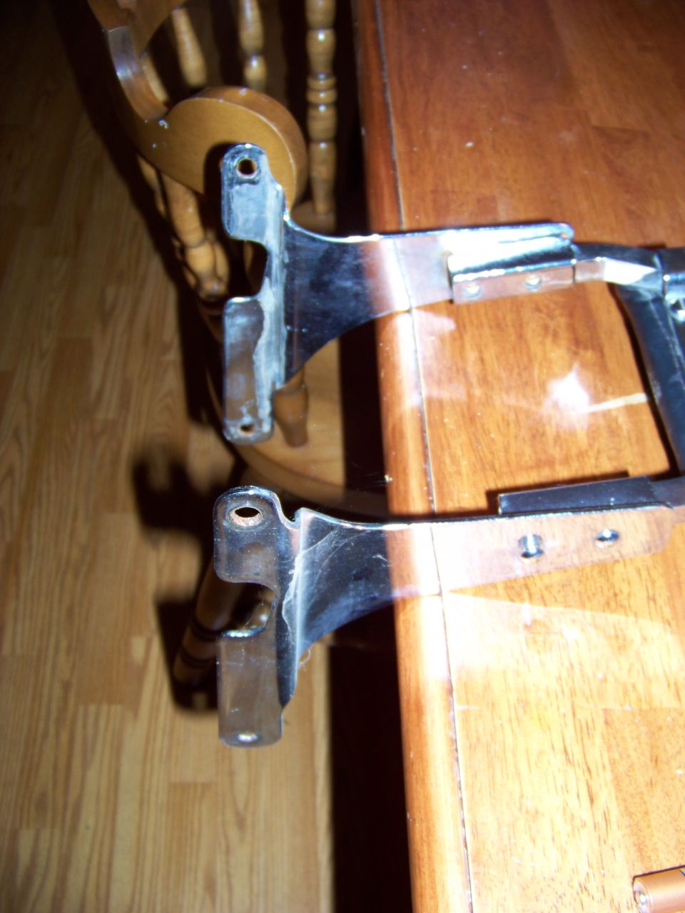 two chrome car parts on a wooden table