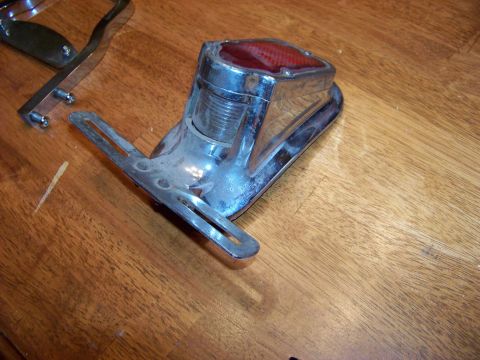 1995 Mercury Grand Marquis - Chrome tail light assembly with red lens, likely for an older vehicle, shown on a wooden surface.