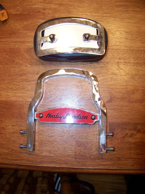 1995 Mercury Grand Marquis - Two Harley-Davidson motorcycle parts, one with the brand name, are displayed on a wooden table.