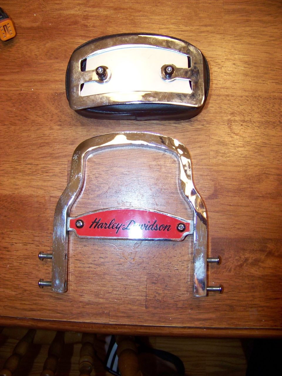 Harley-Davidson emblem and chrome part on wooden surface