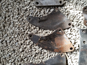 1968 Ford Torino - Various metal brackets are displayed on a bed of gravel, with website information visible.