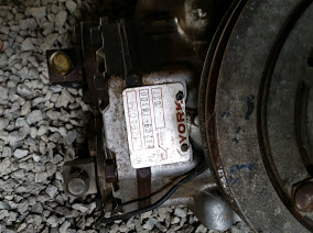 1968 Ford Torino - Close-up of an air conditioning compressor with a data plate, likely a vehicle part.