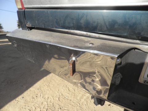 1994 Ford F-250 - The rear of a truck, showing a chrome bumper with a welded metal bracket and a dark colored body panel above.