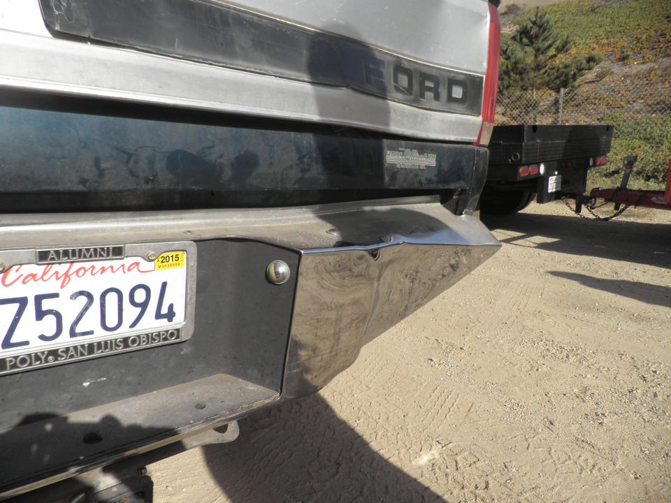 Silver Ford truck rear bumper with California license plate Z52094, towing a flatbed trailer