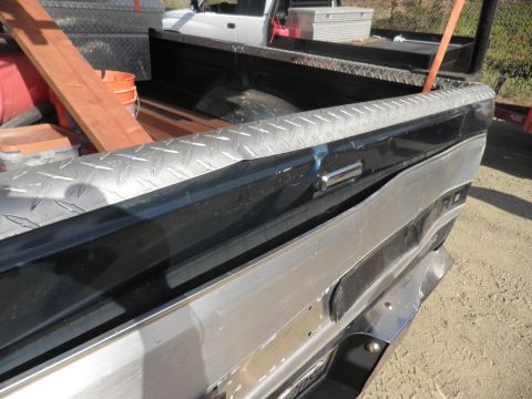 1994 Ford F-250 - A close-up of a truck bed shows diamond plate trim and various tools, with another truck in the background.