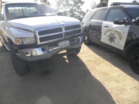 1994 Ford F-250 - A white Dodge Ram pickup truck is parked next to a highway patrol SUV. The truck's license plate is visible.